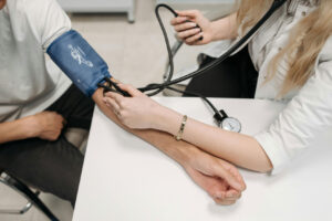 A healthcare professional using a sphygmomanometer to measure a patient's blood pressure in a clinical setting at 60 rpm.